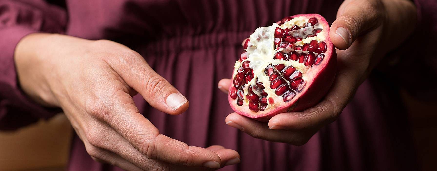 woman holding pomegranate in hand