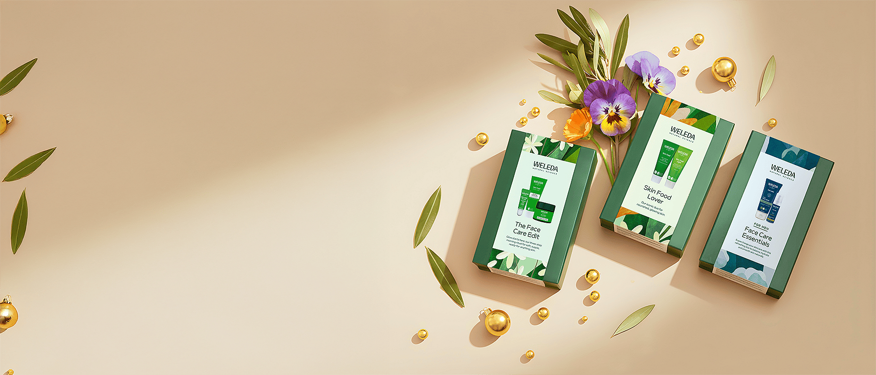 Weleda Chritsmas Gift Sets - The Skin Food Face Care Edit, Skin Food Lover and For Men Face Care Essentials surrounded by yellow christmas boubbles