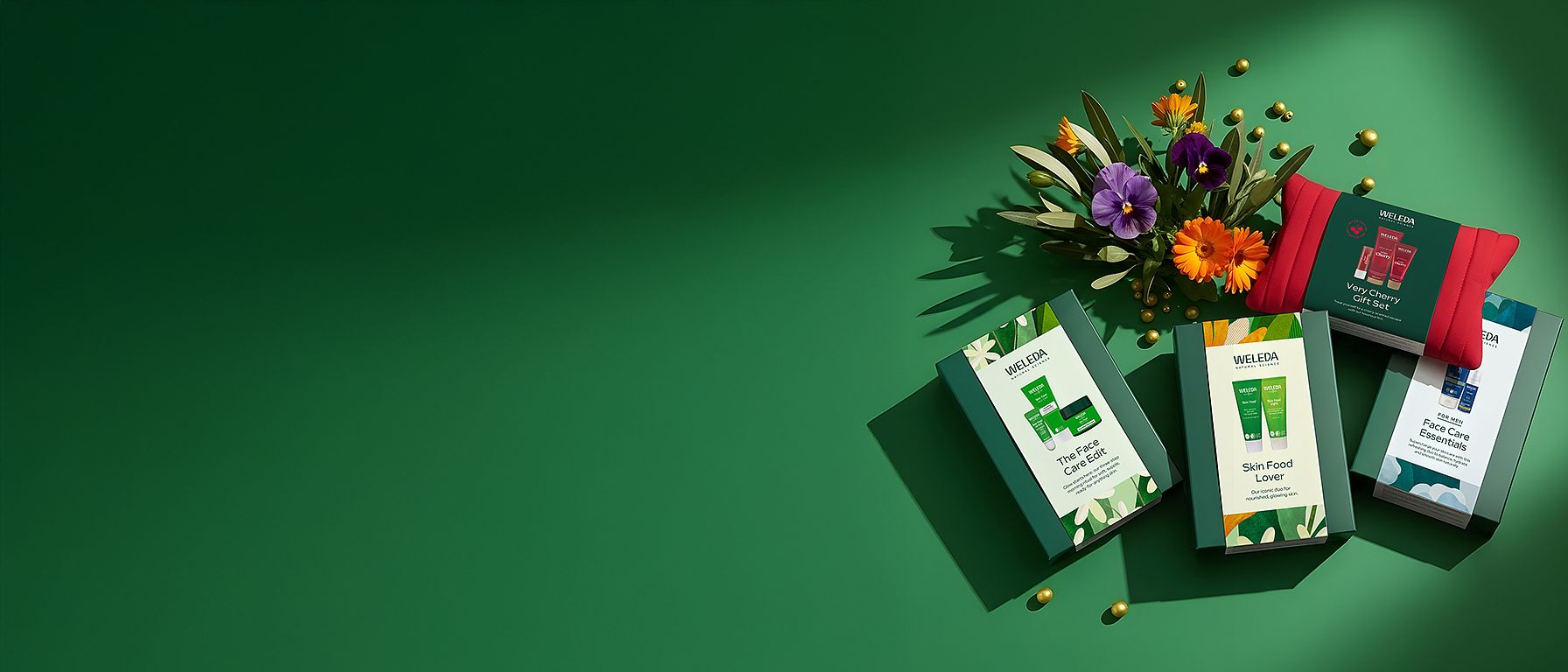 Weleda Chritsmas Gift Sets - The Skin Food Face Care Edit, Skin Food Lover and For Men Face Care Essentials on green background