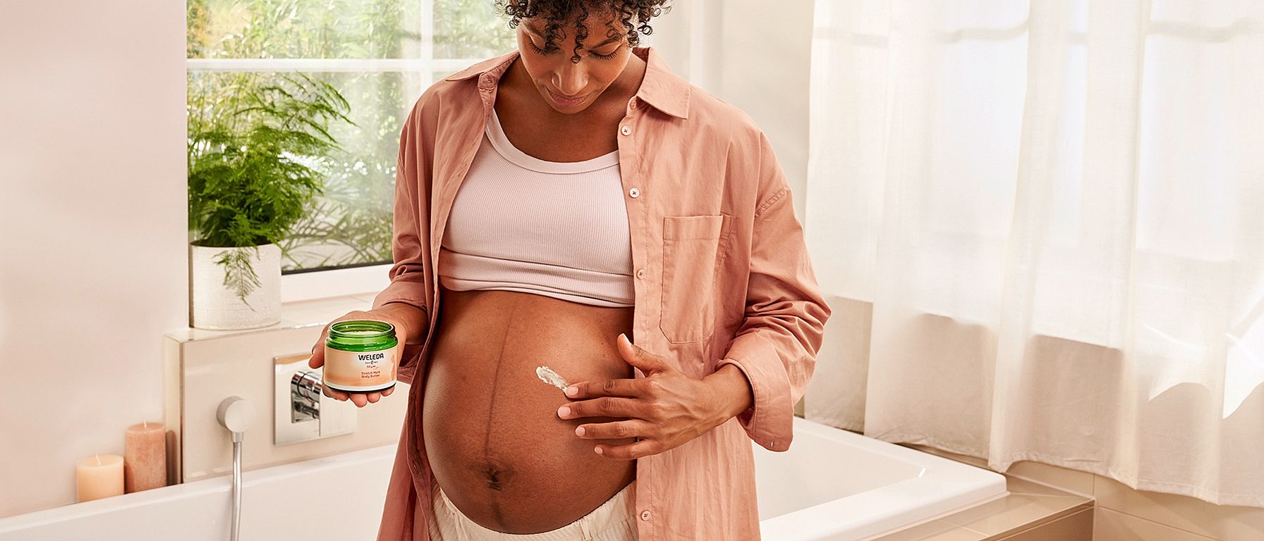 Pregnant woman applying Stretch mark cream to her belly