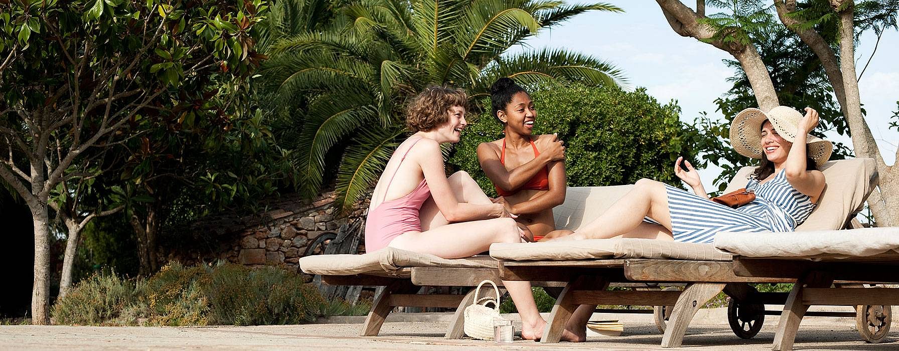 Three women smiling in the sun.