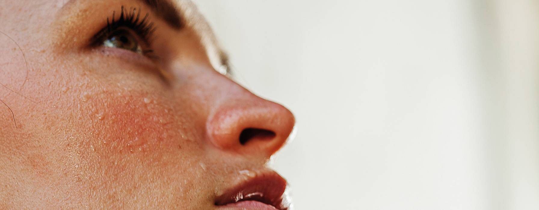 Close up of womans face with sweat drops.