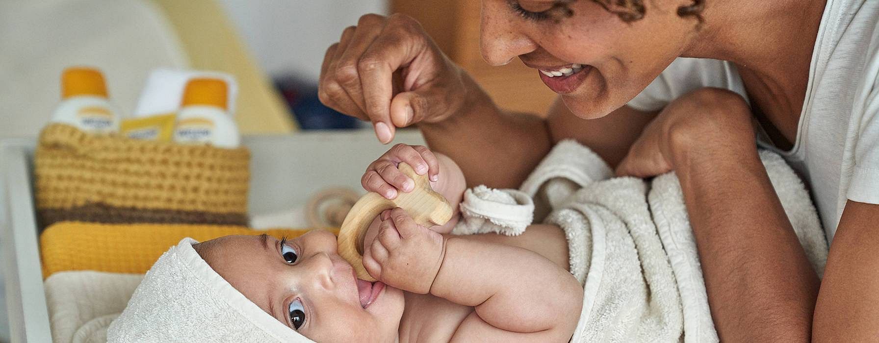 Mother caring for baby wrapped in towel