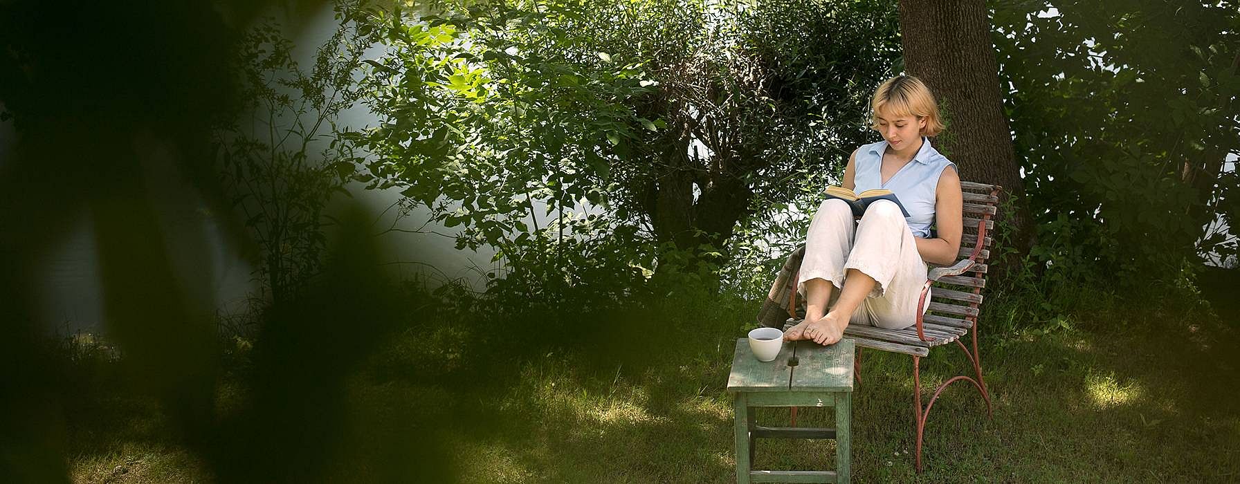 Woman in forest on chair.