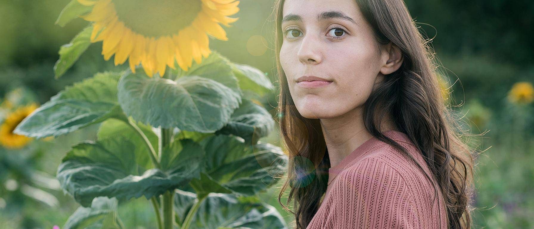 Girl in field with sunflower.
