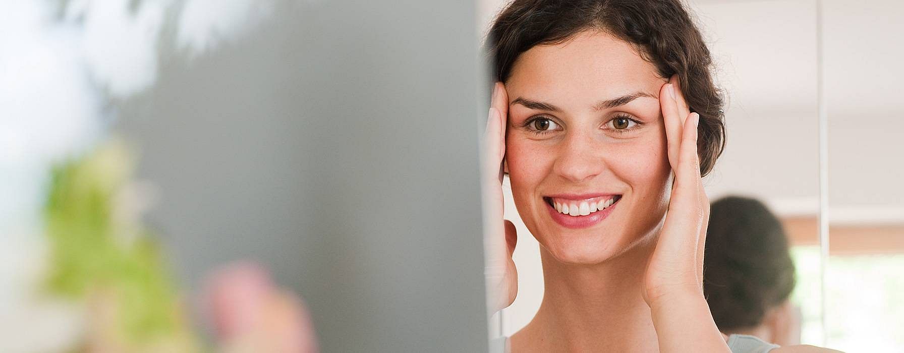 Woman looking at her reflection in a mirror.