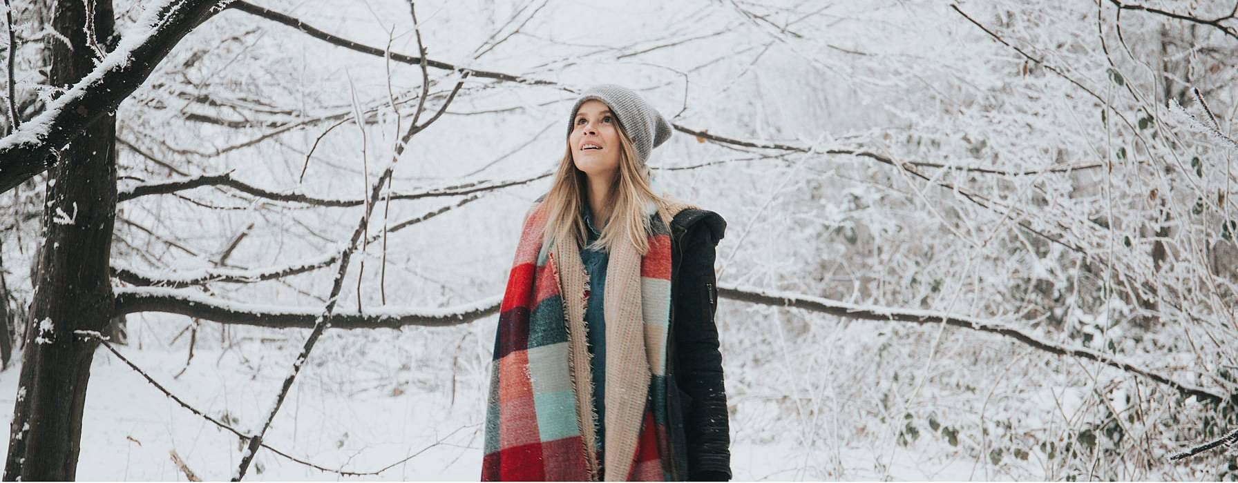 Woman standing in a snowy field.