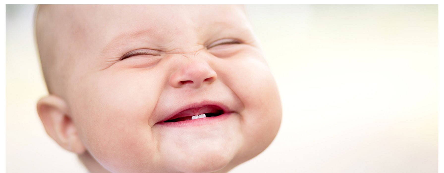 Baby with two bottom teeth grinning