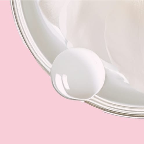 White cream on a pink background.