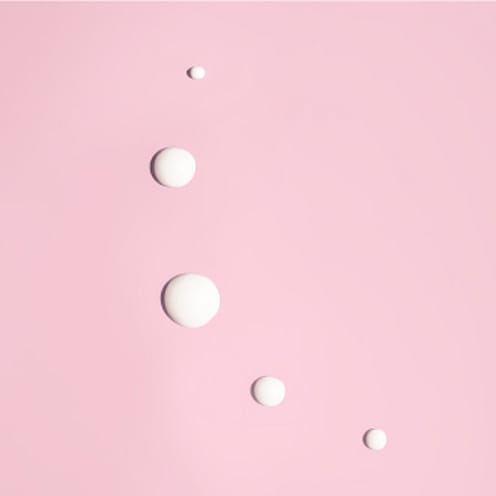 White drops on a pink surface.