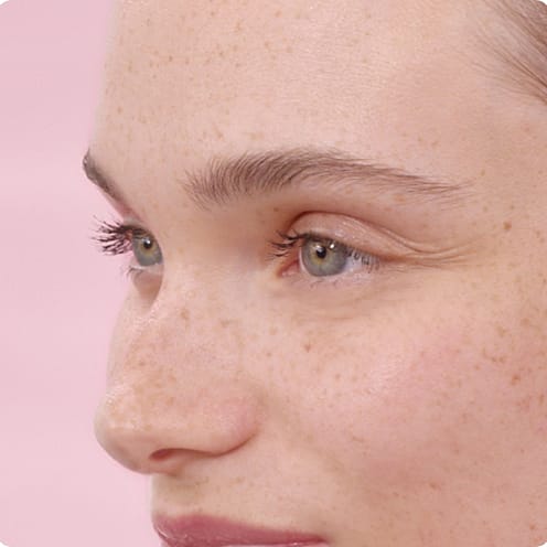 Young woman in front of a pink background.