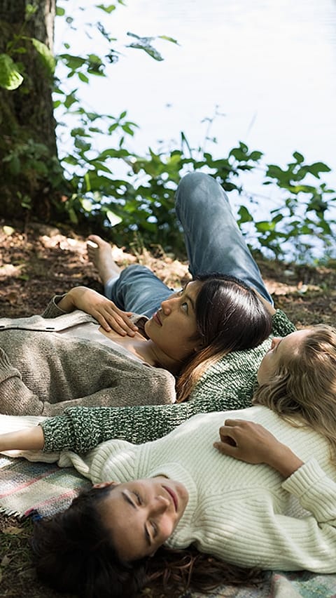 three girls relaxing at a lake