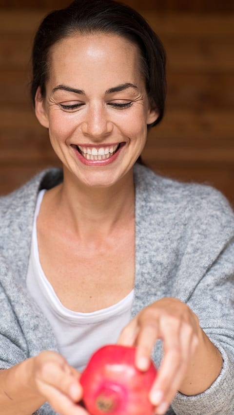 Woman opening a pomegranate