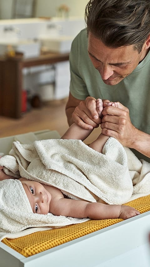 Father changing baby.