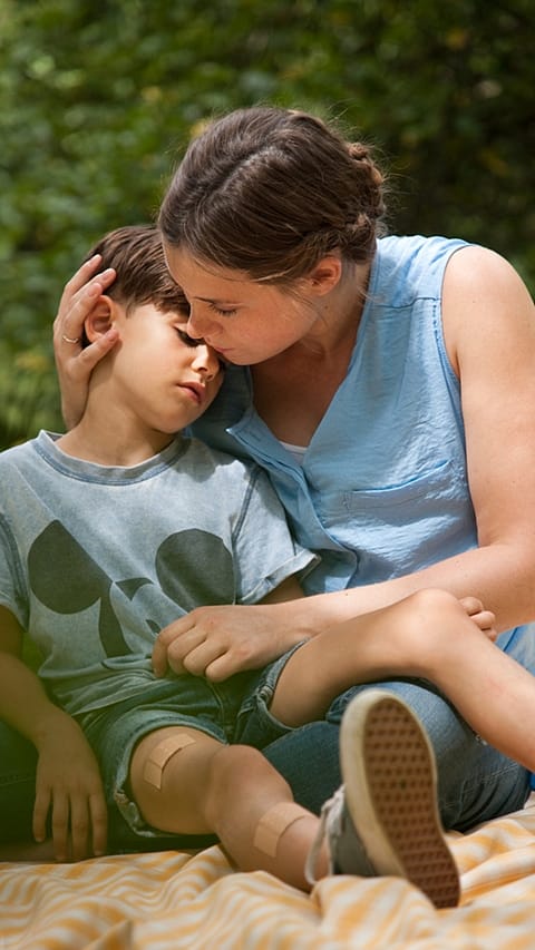 Woman holding child after injury.