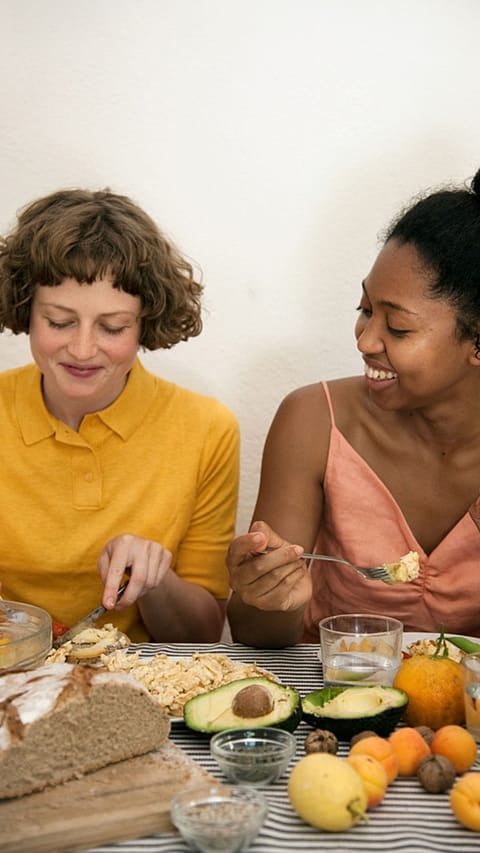Two women sitting next to eachother enoying their healthy diet