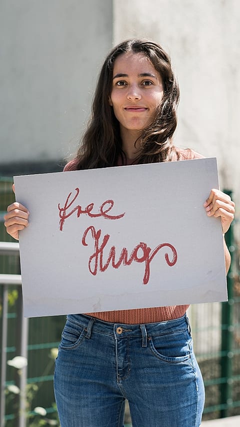 Woman smilng and holding a sign.
