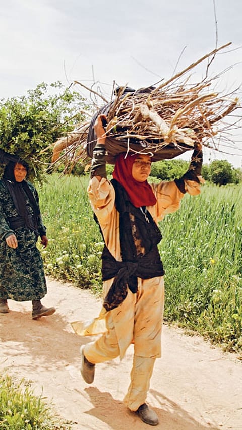woman walking with sticks on their heads