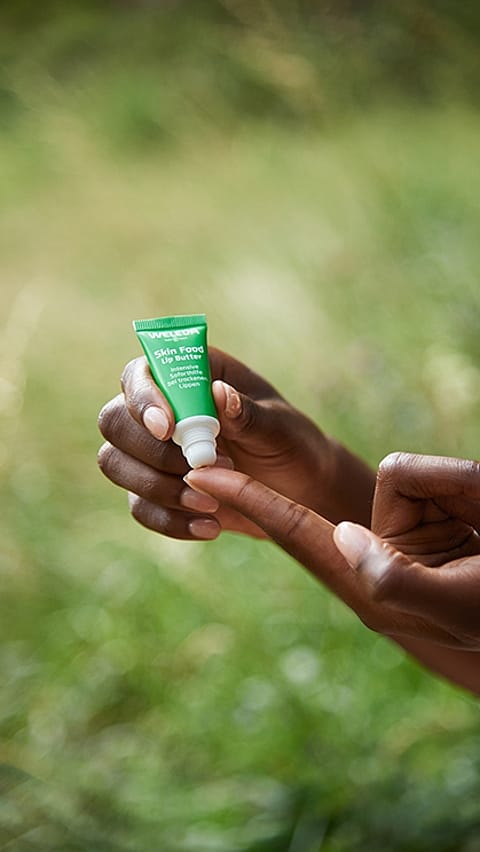 Hand holding Skin Food Lip Balm