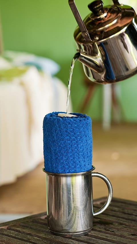 Kettle pouring water over the blue towel.