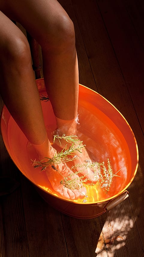 Feet in a foot bath and rosemary.