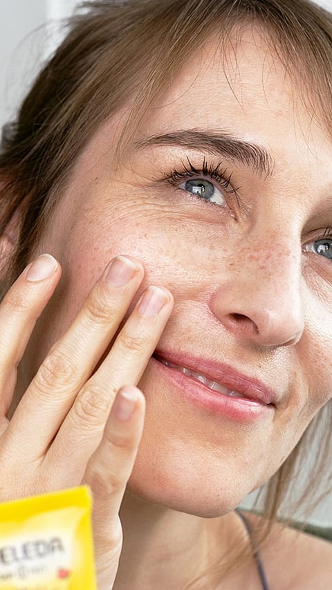 woman applying calendula face cream