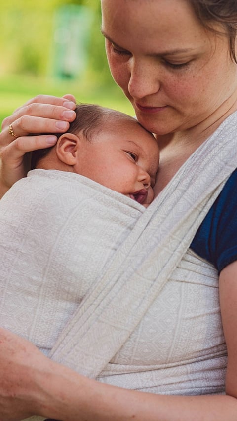 Mother carrying baby in a sling