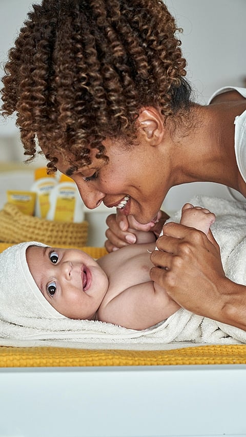 Mother caring for baby wrapped in towel