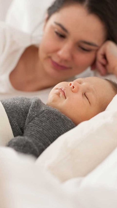 Mother looking at sleep baby