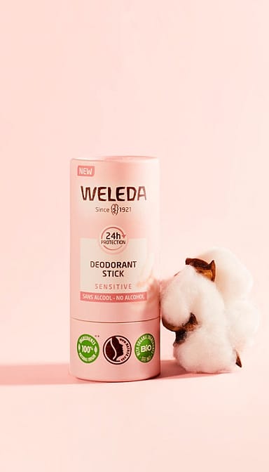 Deodorant Stick Sensitive, next to almond blossom, against pink background.