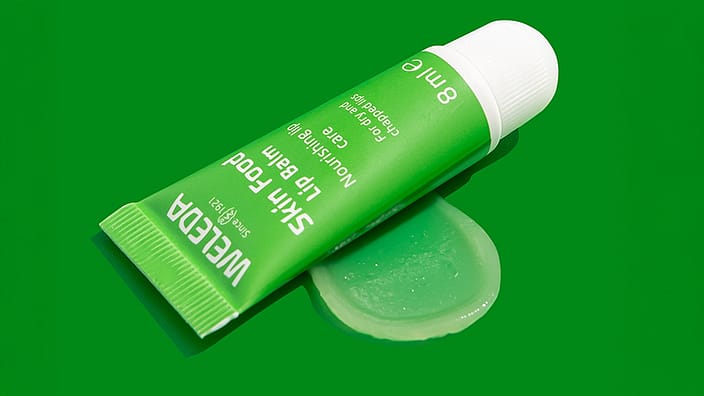 Woman putting Skin Food lip balm on lips