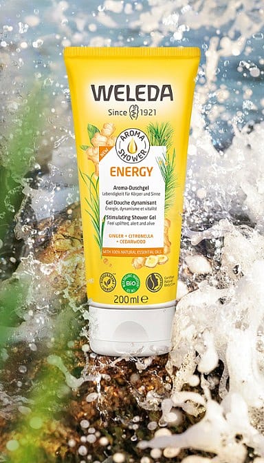 Aroma Shower Energy Body Wash on a rock with water splashing behind.