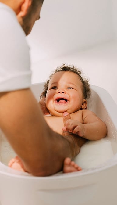 father bathing baby