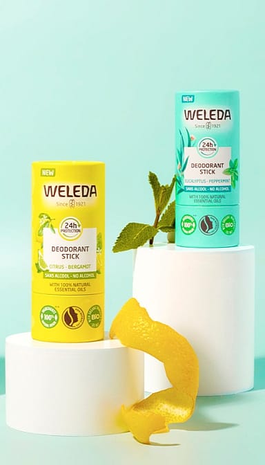 Deodorant stick Citrus-Bergamot and Eucalypptus-peppermint, placed on exaltations against turquoise background.