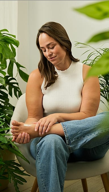 woman applying foot balm to her feet.
