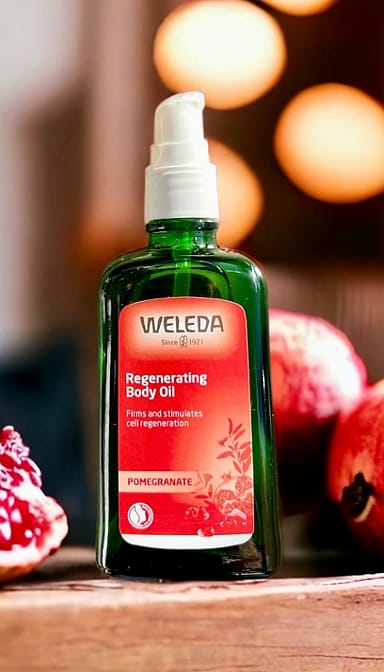 Regenerating Body Oil Pomegranate surrounded by pomegranates.