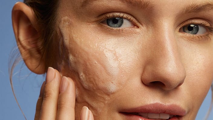Woman cleansing her face with cleansing gel