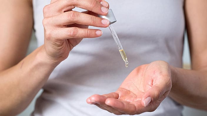 woman droping oil in her hand