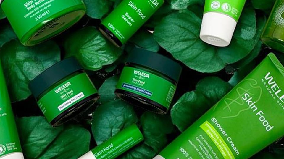 Weleda Skin Food range on a bed of green leaves