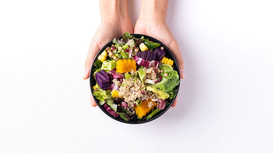 Two women sitting next to eachother and eating.