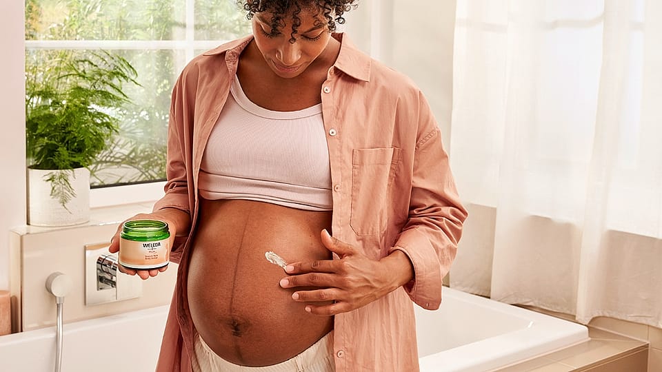 Pregnant woman applying Stretch mark cream to her belly