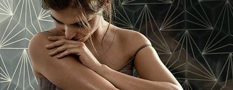 Woman smelling her skin.