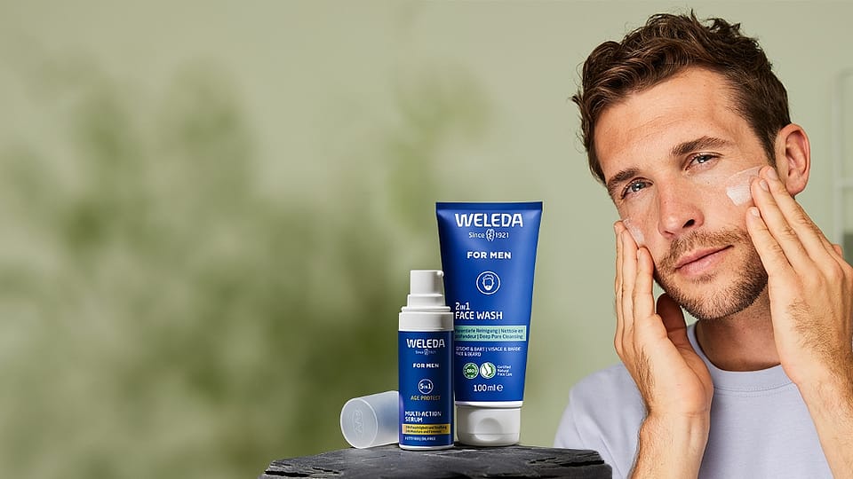 Man in bathroom looking at his face.
