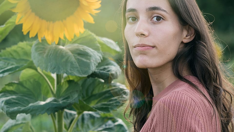 Girl in field with sunflower.