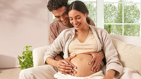 Pregnant woman and partner embracing.