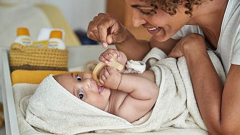 Mother caring for baby wrapped in towel