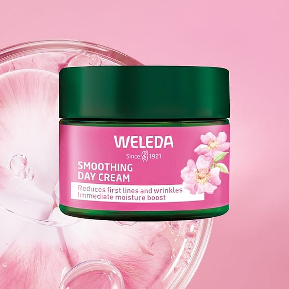 Weleda Smoothing Day Cream in front of a wild rose.