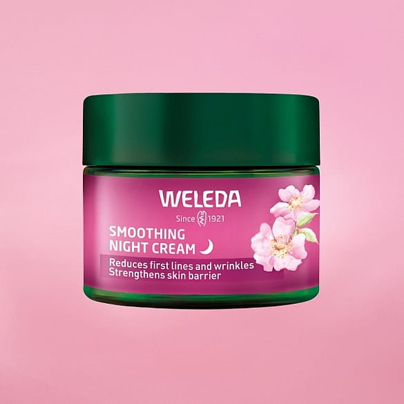 Weleda Smoothing Night Cream in front of a pink background.