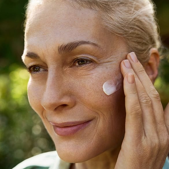 Woman putting a cream on her face
