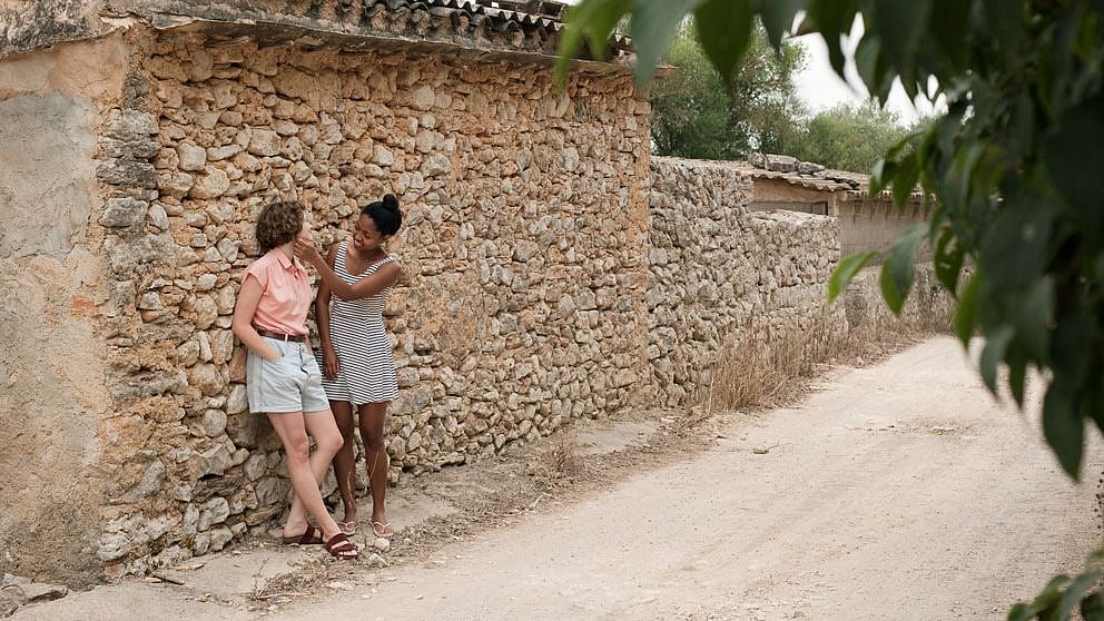 two women laughing infront of a brick wall